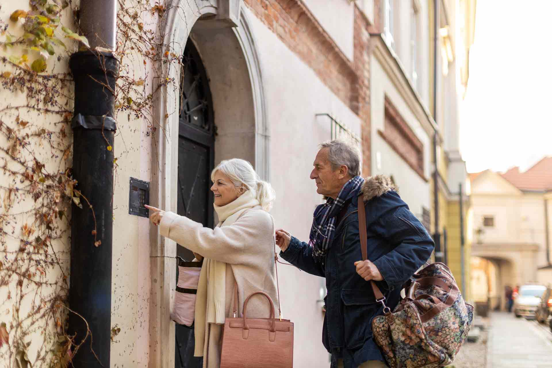 Senior couple ringing doorbell to their guest house